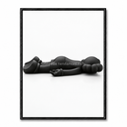 Tableau Kaws noir minimaliste avec personnage allongé horizontalement au sol sur fond blanc.
