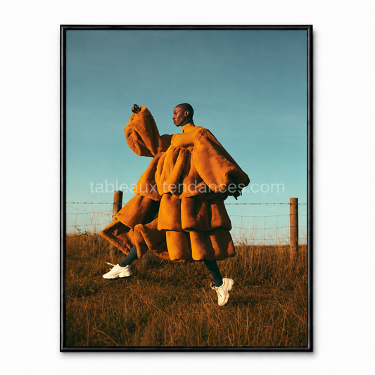 Orange Freedom — silhouette en tenue orange sculpturale dans un paysage naturel, tableau mode contemporain