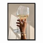 Tableau décoratif Verre Solaire, verre de vin lumineux tenu par une main sur fond beige