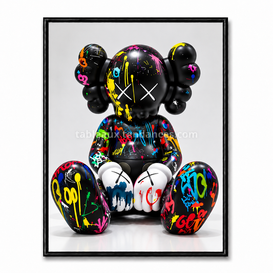 Tableau avec personnage Companion noir assis décoré d’éclaboussures de peinture multicolores.