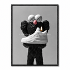 Tableau Kaws street art avec personnage noir texturé présentant une sneaker blanche avec une flamme.